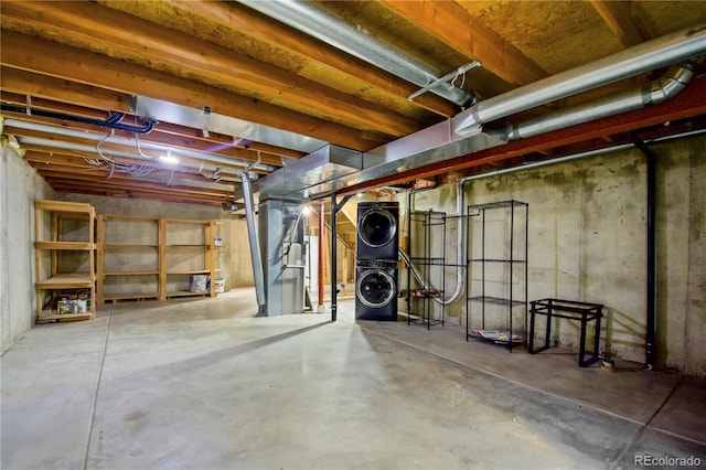 unfinished basement featuring stacked washer / drying machine