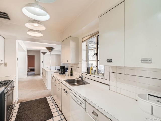 kitchen with gas stove, white cabinetry, dishwasher, sink, and decorative backsplash