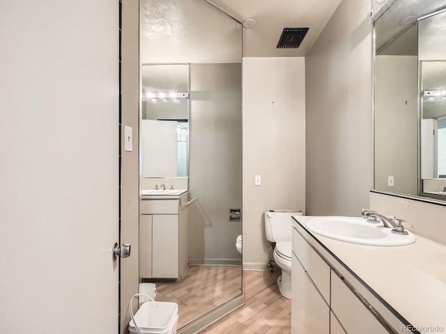 bathroom featuring hardwood / wood-style floors, vanity, and toilet