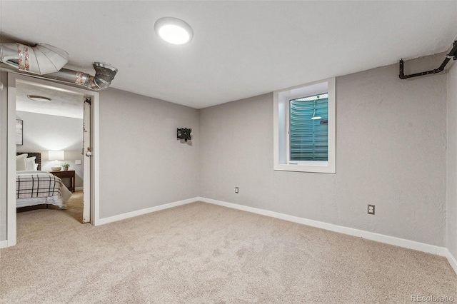 basement featuring light colored carpet