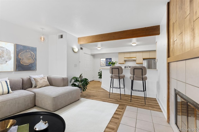 20 S Boulder Cir Unit 2109, Boulder, CO 80303 - living room featuring light wood finished floors, beamed ceiling, a tile fireplace, and baseboards