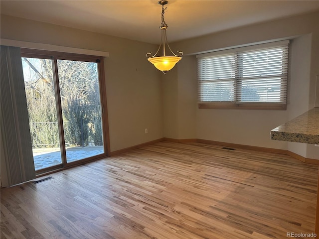 unfurnished room with a healthy amount of sunlight and hardwood / wood-style floors