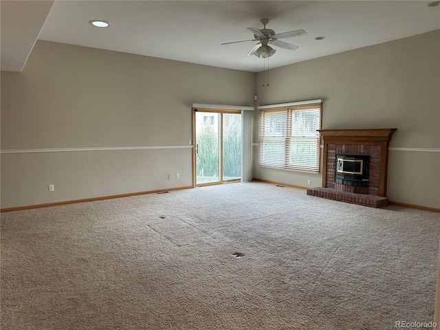 unfurnished living room with ceiling fan, a fireplace, and carpet flooring