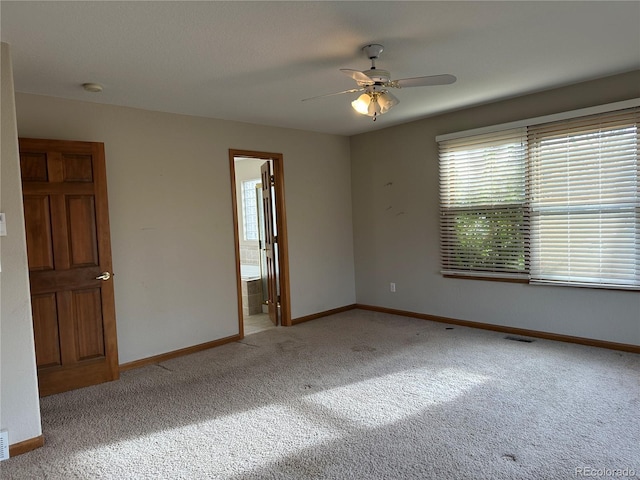 empty room featuring light colored carpet and ceiling fan