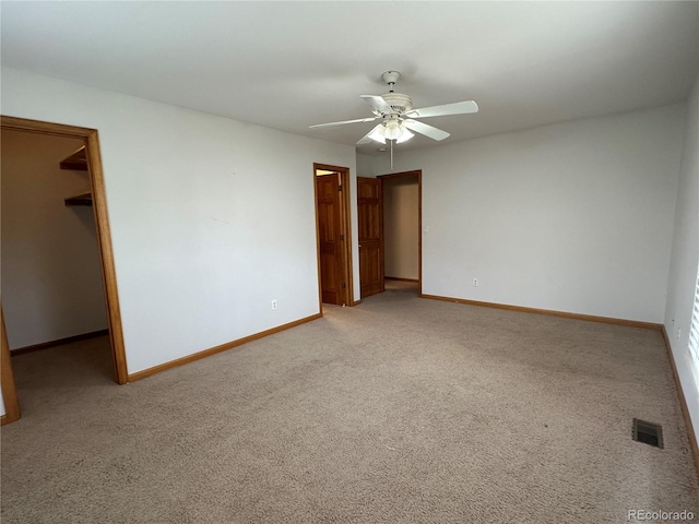 empty room featuring ceiling fan and carpet