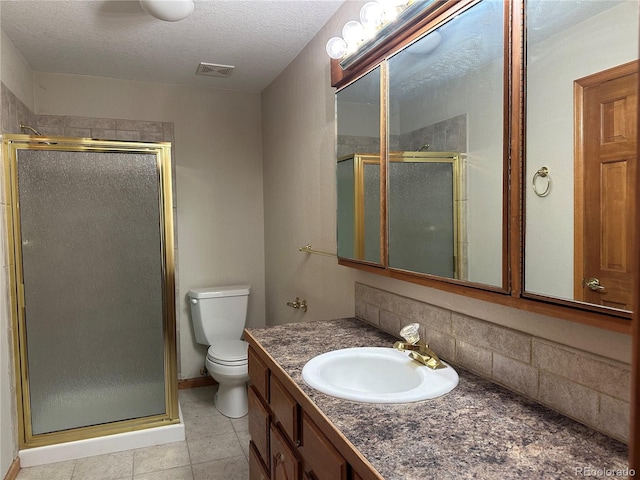 bathroom featuring a shower with shower door, backsplash, vanity, toilet, and a textured ceiling