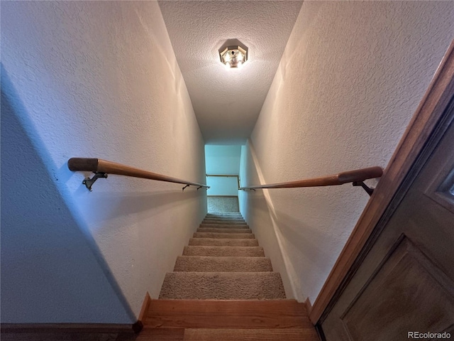 staircase with a textured ceiling