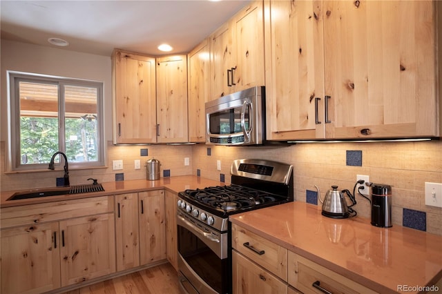 344 Puma Pl, Fairplay, CO 80440 - kitchen featuring stainless steel appliances, light brown cabinetry, light countertops, backsplash, and light wood-style flooring