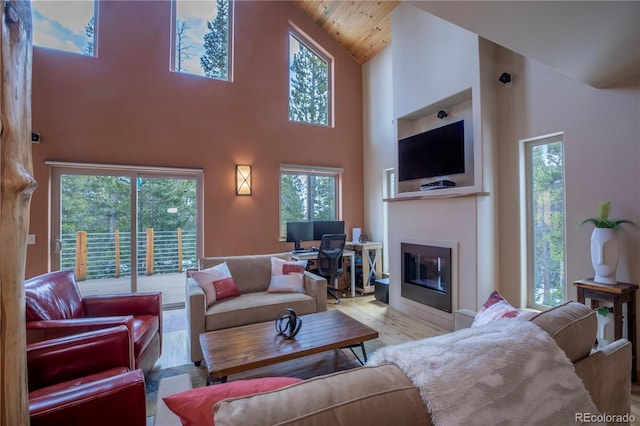 344 Puma Pl, Fairplay, CO 80440 - living room featuring high vaulted ceiling, plenty of natural light, a glass covered fireplace, wood finished floors, and wood ceiling