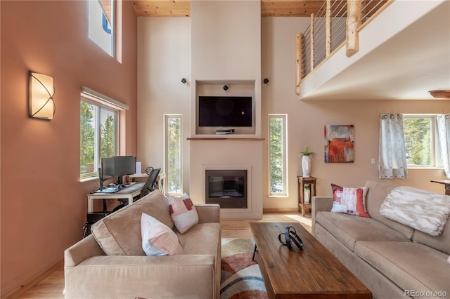 344 Puma Pl, Fairplay, CO 80440 - living area with a high ceiling, a glass covered fireplace, plenty of natural light, wood finished floors, and wood ceiling