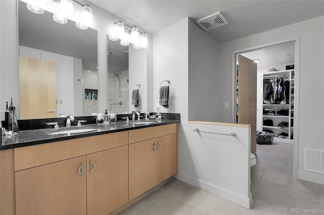 2229 Blake St Unit 505, Denver, CO 80205 - bathroom with a shower stall, double vanity, a walk in closet, and baseboards