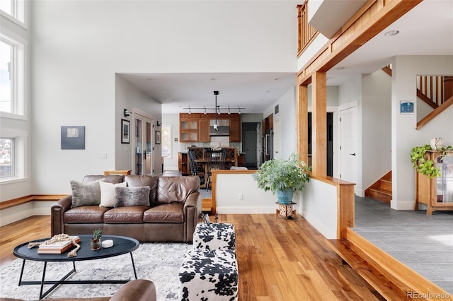 living room featuring a towering ceiling and light wood-type flooring