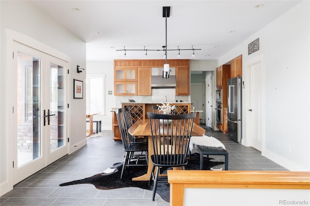 dining area featuring sink, rail lighting, and french doors