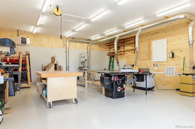 garage with a workshop area and wood walls