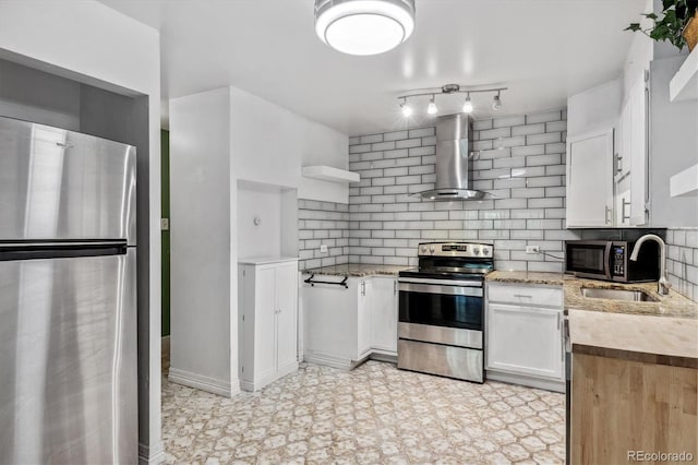 kitchen with white cabinets, backsplash, light stone counters, stainless steel appliances, and wall chimney exhaust hood