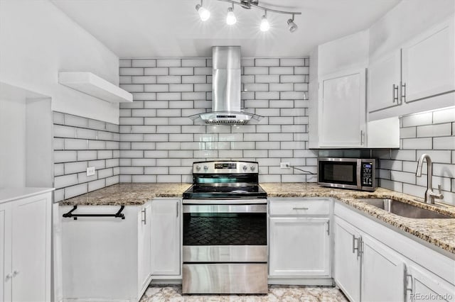 kitchen featuring light stone counters, stainless steel appliances, white cabinetry, sink, and wall chimney exhaust hood