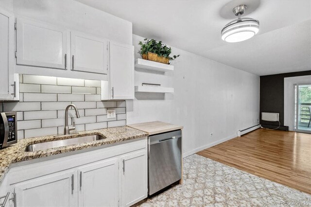 kitchen featuring appliances with stainless steel finishes, sink, white cabinets, and light hardwood / wood-style floors