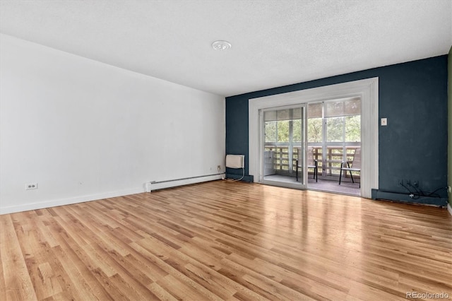 empty room featuring a baseboard heating unit, a textured ceiling, and light hardwood / wood-style floors