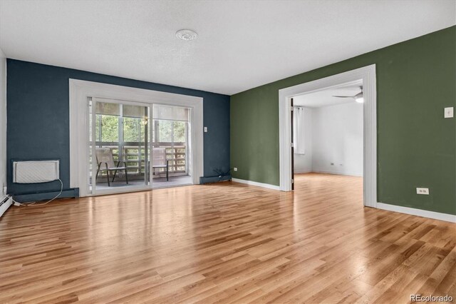 spare room with a textured ceiling and light hardwood / wood-style floors