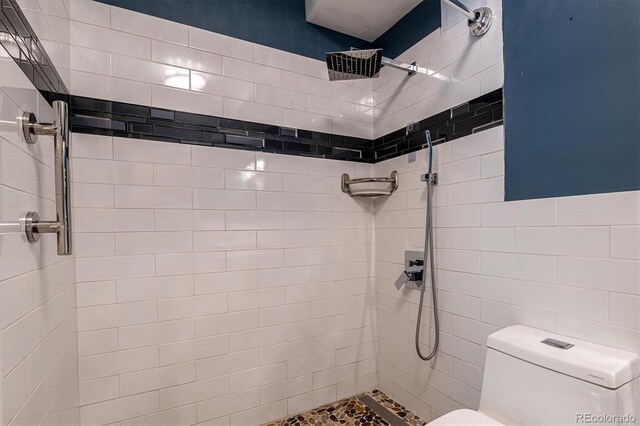 bathroom with tiled shower and toilet