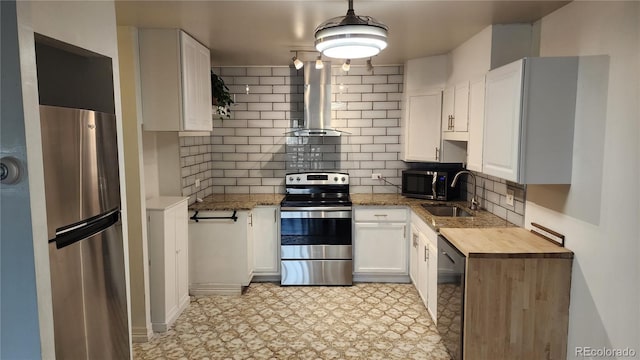 kitchen featuring a sink, wall chimney exhaust hood, appliances with stainless steel finishes, and white cabinetry