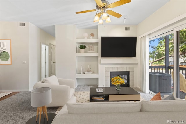 10784 W 63rd Pl Unit 205, Arvada, CO 80004 - living area with built in features, a tile fireplace, and a ceiling fan
