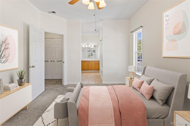 10784 W 63rd Pl Unit 205, Arvada, CO 80004 - bedroom with light carpet, connected bathroom, and ceiling fan