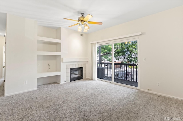 10784 W 63rd Pl Unit 205, Arvada, CO 80004 - unfurnished living room featuring a ceiling fan, carpet flooring, built in features, and a tile fireplace