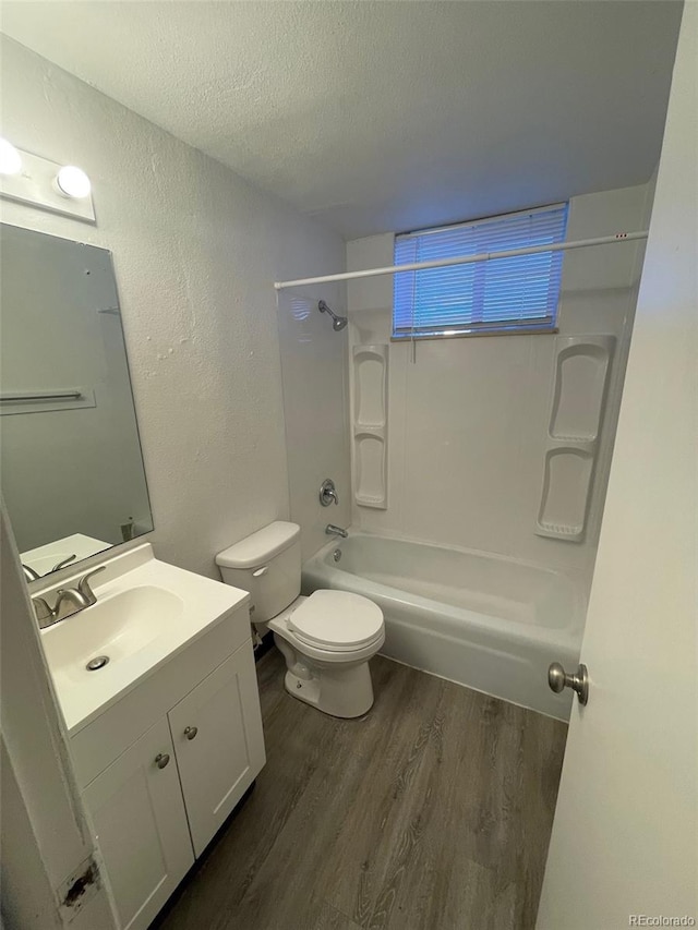 full bathroom with shower / bath combination, a textured ceiling, toilet, vanity, and hardwood / wood-style flooring