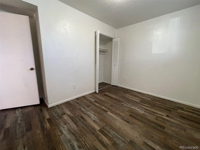 unfurnished bedroom with a closet and dark hardwood / wood-style floors