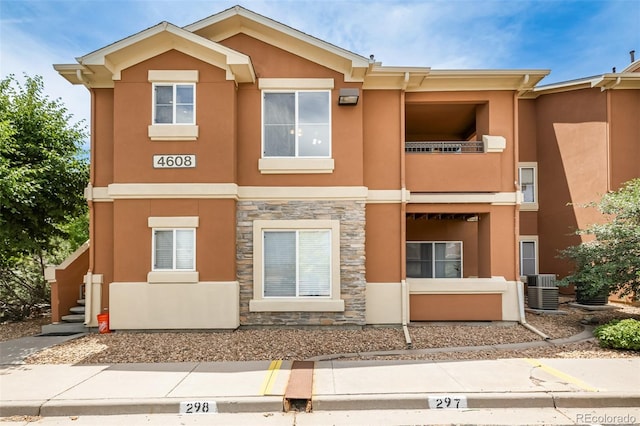 view of front of property featuring cooling unit and a balcony