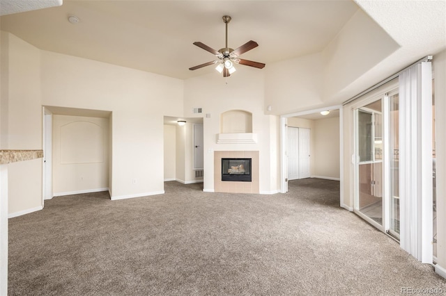 unfurnished living room with carpet, ceiling fan, and a tile fireplace