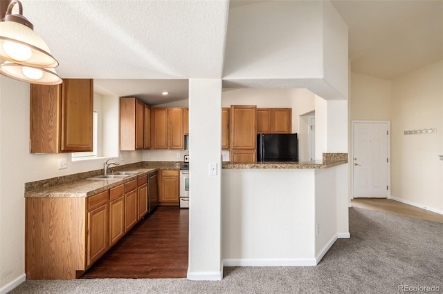 kitchen featuring a textured ceiling, stainless steel appliances, sink, dark colored carpet, and a high ceiling