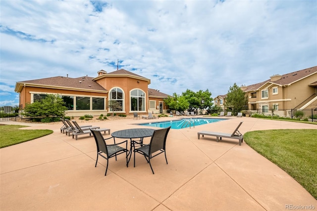 view of pool with a lawn and a patio area