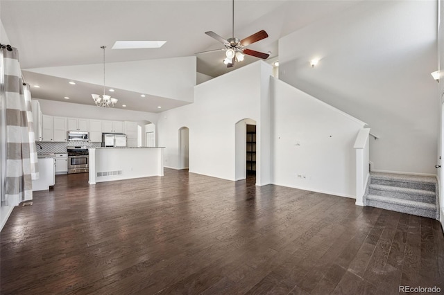 13135 Devils Thumb Pl, Peyton, CO 80831 - unfurnished living room featuring a chandelier, dark wood-style floors, ceiling fan, stairway, and high vaulted ceiling