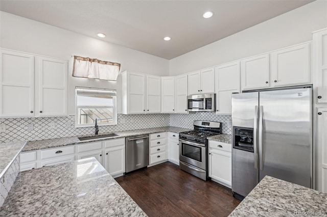 13135 Devils Thumb Pl, Peyton, CO 80831 - kitchen with appliances with stainless steel finishes, a sink, dark wood-style floors, light stone countertops, and decorative backsplash