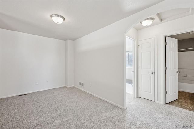 13135 Devils Thumb Pl, Peyton, CO 80831 - unfurnished bedroom with carpet flooring, arched walkways, and baseboards