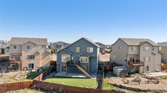 13135 Devils Thumb Pl, Peyton, CO 80831 - rear view of house with stairway, a residential view, a fenced backyard, and a patio area