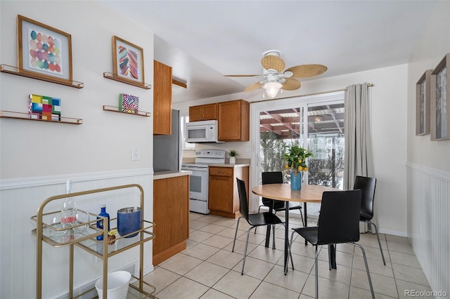 kitchen featuring ceiling fan, light tile patterned floors, and white appliances