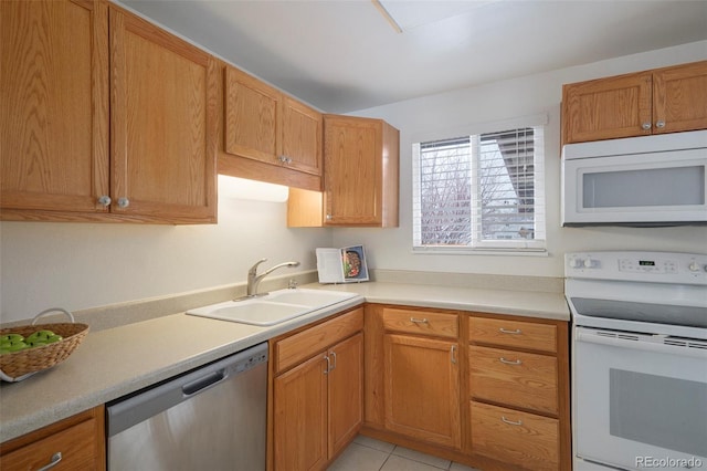 kitchen featuring white appliances, sink, and light tile patterned floors