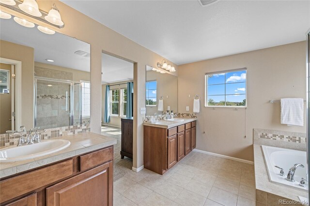 9530 Gray St, Westminster, CO 80031 - bathroom featuring two vanities, a stall shower, a garden tub, and tile patterned floors