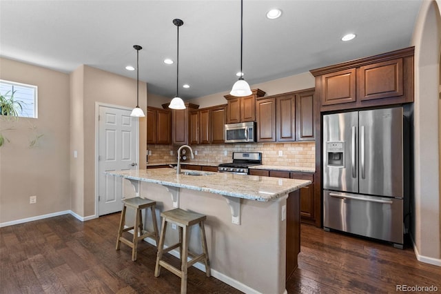 9530 Gray St, Westminster, CO 80031 - kitchen with stainless steel appliances, backsplash, dark wood-type flooring, light stone countertops, and a kitchen bar