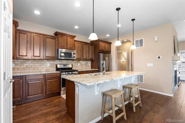 9530 Gray St, Westminster, CO 80031 - kitchen with stainless steel appliances, dark wood-type flooring, an island with sink, backsplash, and recessed lighting