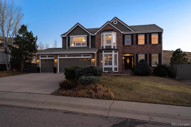 view of front of house featuring brick siding, concrete driveway, a front yard, and fence