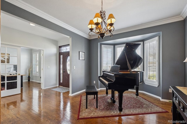 sitting room with a chandelier, baseboards, wood finished floors, and crown molding