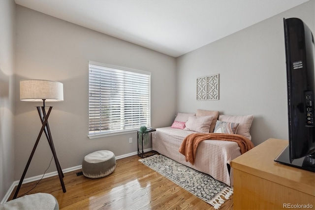 bedroom with baseboards and wood finished floors