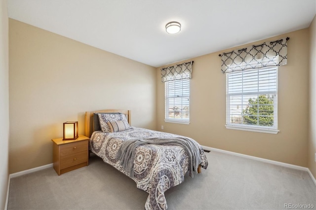 bedroom with baseboards and light carpet