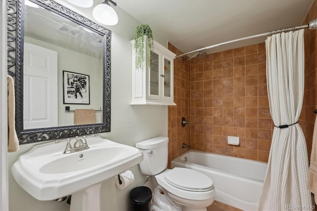 full bathroom featuring toilet, shower / bath combo, visible vents, and a sink