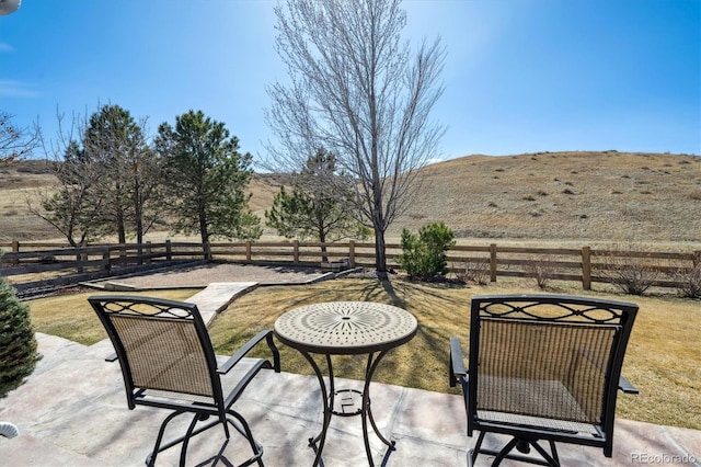 view of patio featuring a mountain view and fence