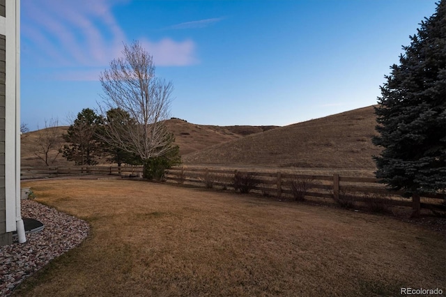 view of yard featuring fence and a mountain view